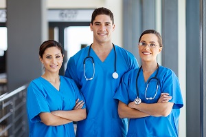 Three nurses in blue scrubs